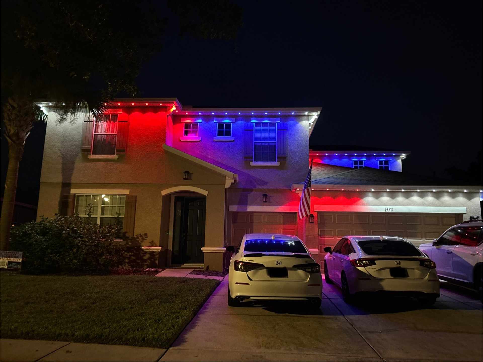 Two-story home with red, white, and blue patriotic LED lighting